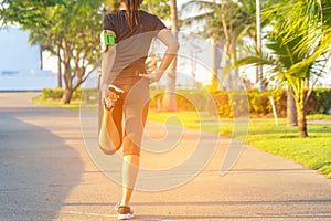 Healthy Life. Asian fitness woman runner stretching legs before run outdoor workout in the park