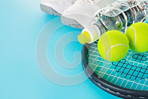 Healthy Life Sport Concept. Sneakers with Tennis Balls, Towel and Bottle of Water on Bright Blue Background. Copy Space