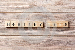 Healthy life word written on wood block. healthy life text on table, concept