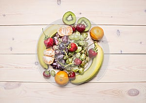 Healthy lifestyle background with various colorful fruit, laid out in the center the white wooden table top view