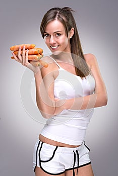Healthy lifestyle! Beautiful woman holding lot of carrots