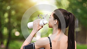 Healthy Lifestyle Concept. Asian jogger girl drinking water, resting after running outdoors