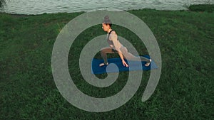 Healthy lifestyle concept. Beautiful young girl doing yoga in morning at lake.