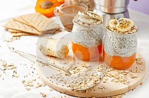 Healthy lifestyle concept. Breakfast with coffee, crackers, oat flakes, chia seed pudding with banana and apricot