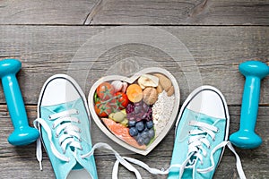 Healthy lifestyle concept with food in heart and sports fitness accessories