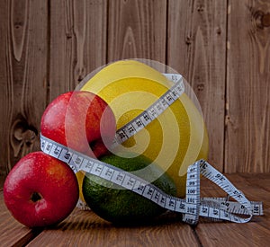 Healthy lifestyle concept. Pomelo, avocado, apples on wooden background. Diet, health, fitness, measuring tape, positive