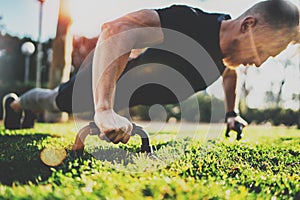 Healthy lifestyle concept.Training outdoors.Handsome sport athlete man doing pushups in the park on the sunny morning