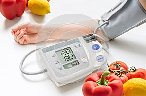 Healthy lifestyle concept. Woman is measuring blood pressure with monitor.