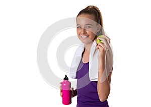 Healthy lifestyle - fitness girl eating apple smiling happy looking at camera and holding a water bottle. Pretty Caucasian woman