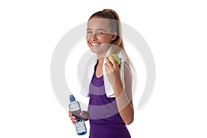 Healthy lifestyle - fitness girl eating apple smiling happy looking at camera and holding a water bottle. Pretty Caucasian woman