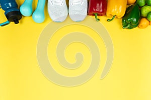 Healthy lifestyle, food and sport concept. athlete`s equipment and fresh fruit and vegetable on yellow background