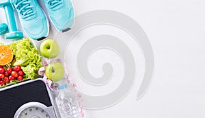 Healthy lifestyle, food and sport concept. Top view of sport shoes, weight scale measuring tape, blue dumbbell, sport water