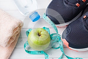 Healthy lifestyle, food and water, athlete`s equipment on grey background. Flat lay. Top view with copy space