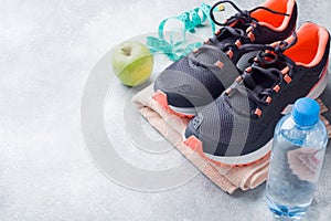 Healthy lifestyle, food and water, athlete`s equipment on grey background. Flat lay. Top view with copy space