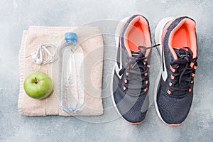 Healthy lifestyle, food and water, athlete`s equipment on grey background. Flat lay. Top view with copy space