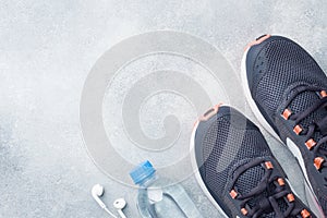 Healthy lifestyle, food and water, athlete`s equipment on grey background. Flat lay. Top view with copy space