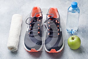 Healthy lifestyle, food and water, athlete`s equipment on grey background. Flat lay. Top view with copy space