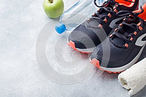 Healthy lifestyle, food and water, athlete`s equipment on grey background. Flat lay. Top view with copy space