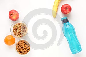 Healthy lifestyle: food on white background. Flat view with copy space. Eco bottle, oatmeal and fruits.