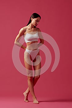 Healthy lifestyle. Full-length image of beautiful young woman with slim, fit body shape standing in white cotton