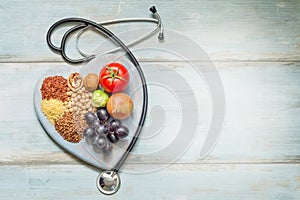 Healthy lifestyle and healthcare concept with food, heart and stethoscope