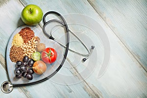 Healthy lifestyle and healthcare concept with food, heart and stethoscope