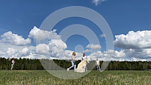 Healthy lifestyle and love for pets. family with a big dog playing with a ball on the field