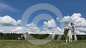 Healthy lifestyle and love for pets. family with a big dog playing with a ball on the field