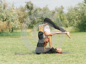 Healthy lifestyle modern activity. Young couple doing acro bird yoga pose.