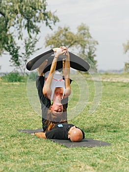 Healthy lifestyle modern activity. Young couple doing acro bird yoga pose.