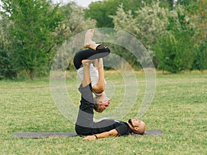 Healthy lifestyle modern activity. Young couple doing acro bird yoga pose.