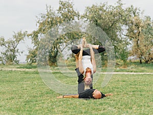 Healthy lifestyle modern activity. Young couple doing acro bird yoga pose.