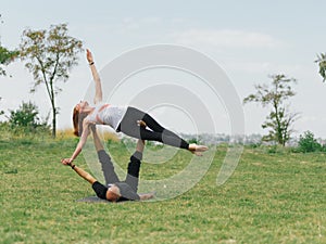 Healthy lifestyle modern activity. Young couple doing acro bird yoga pose.