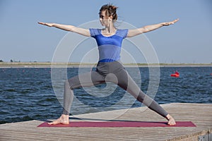 Healthy lifestyle in nature,Woman doing yoga exercise on mat in park near lake