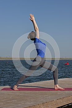 Healthy lifestyle in nature,Woman doing yoga exercise on mat in park near lake