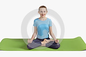 Healthy lifestyle. Relaxation wellness meditation Portrait of teenage girl practicing yoga meditation exercise on green rug.