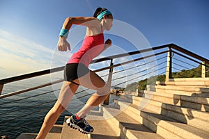 Healthy lifestyle sports woman running up on stone stairs sunrise