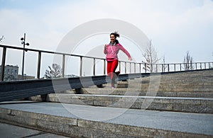Healthy lifestyle sports woman running up on stone stairs at sunrise seaside