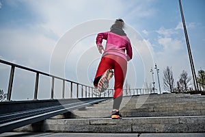 Healthy lifestyle sports woman running up on stone stairs at sunrise seaside