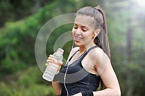 healthy lifestyle sporty woman with headphone and bottle of water in beautiful nature area