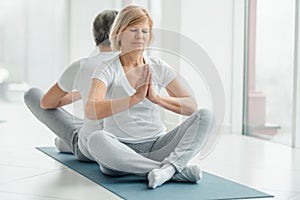 Healthy lifestyle and wellness concept. Senior couple doing yoga together