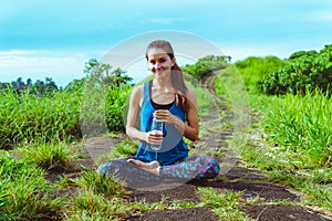 Healthy lifestyle. Woman drink water in lotus pose.