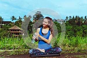 Healthy lifestyle. Woman drink water in lotus pose.