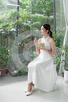 Healthy lifestyle woman eating salad smiling happy indoors on beautiful day