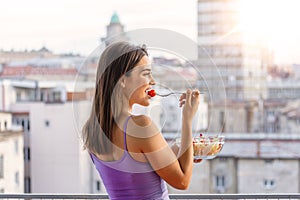 Healthy lifestyle woman eating salad smiling happy outdoors on beautiful day. Young female eating healthy food outside in summer