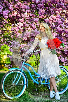 Healthy lifestyle. Woman in garden. Sakura tree blooming. Spring holidays. Transportation and travel. Sakura season