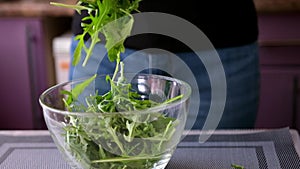 Healthy lifestyle - Woman pouring arugula into glass bowl