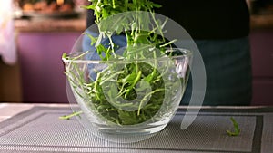 Healthy lifestyle - Woman pouring arugula into glass bowl