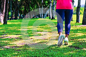 Healthy lifestyle woman runner jogging on beautiful summer day in the public green park. Fitness and workout wellness concept