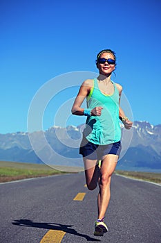 Healthy lifestyle woman runner running on road